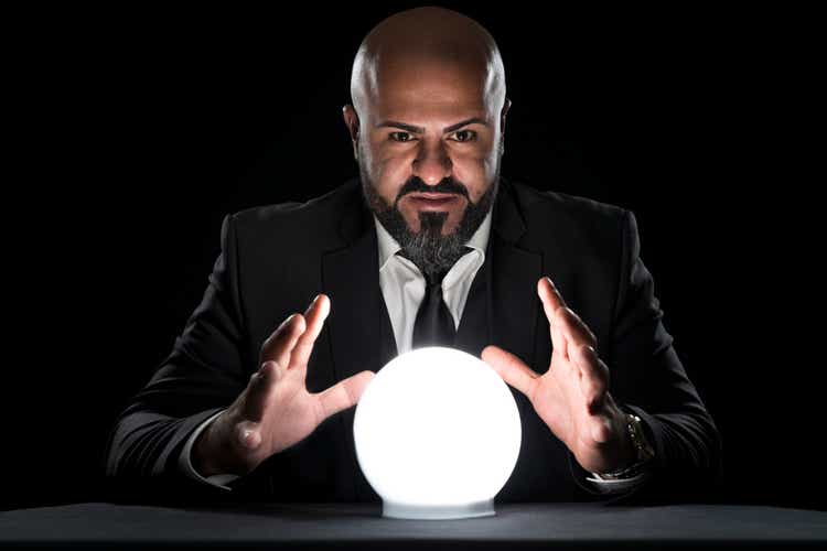 mysterious fortune teller gesturing at crystal ball