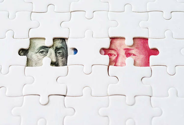 US and Chinese paper currency under jigsaw puzzle