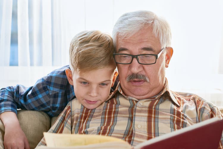 Grandson and grandfather reading book
