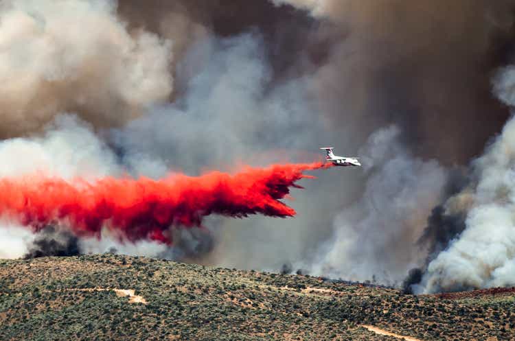 White Aircraft Dropping Fire Retardant as it Battles Raging Wildfire