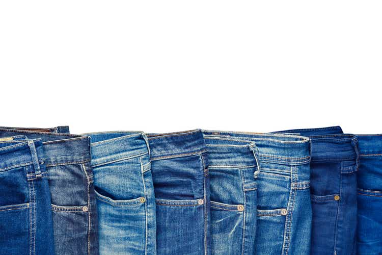 Row of fashion different jeans isolated on white.