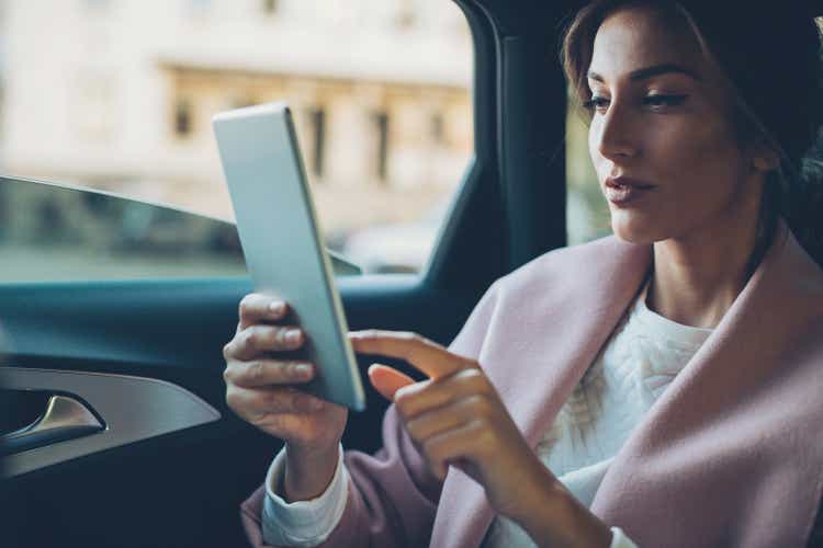 Woman with digital tablet in a car