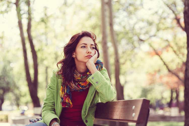 Unhappy girl sitting at bench