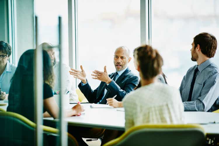 Mature businessman hosting meeting in office