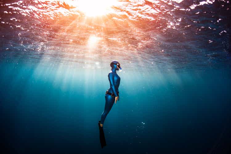 Woman free diver ascending from the depth