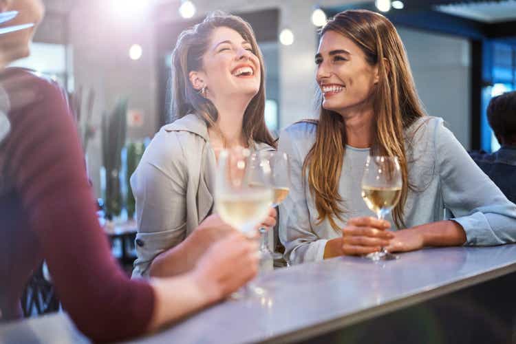 Friends laughing while enjoying drinks in bar