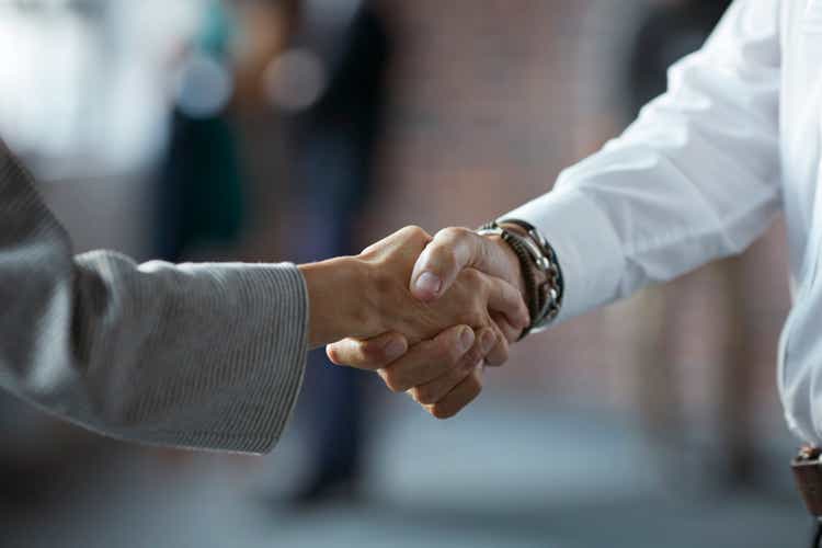 Businesspeople making handshake at conference