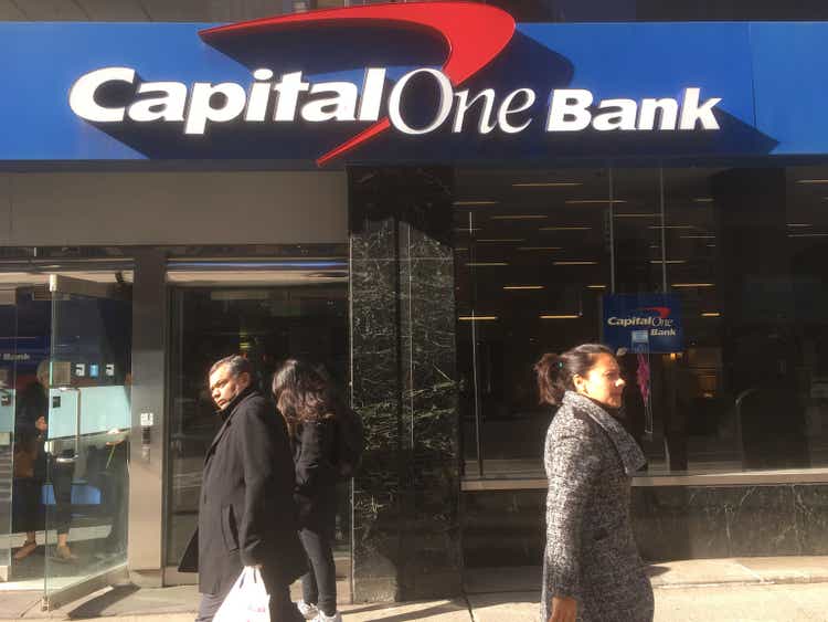 New York City - 28 January 2017: Three people pass the Midtown Manhattan Capital One Bank on 6th Avenue in New York City. Exterior of Capital One bank on a sunny afternoon.