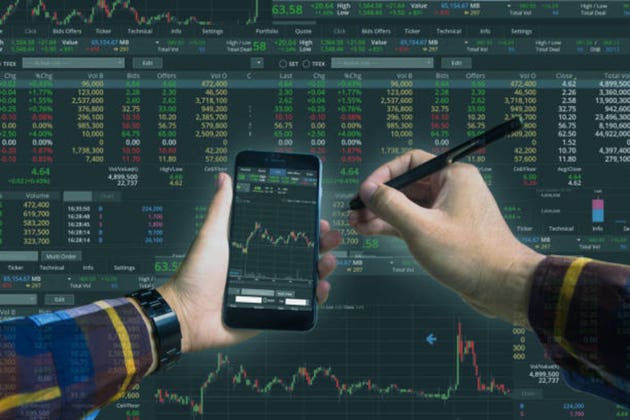 Double exposure of Hand holding smart phone checking financial stats on screen for trading stock concept.