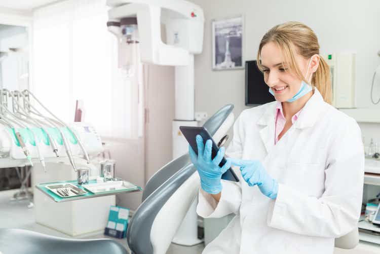 Dentist using digital tablet and ordering supplies