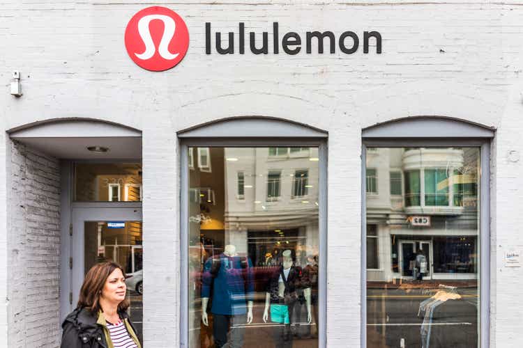 Lululemon building exterior with woman walking by and sign