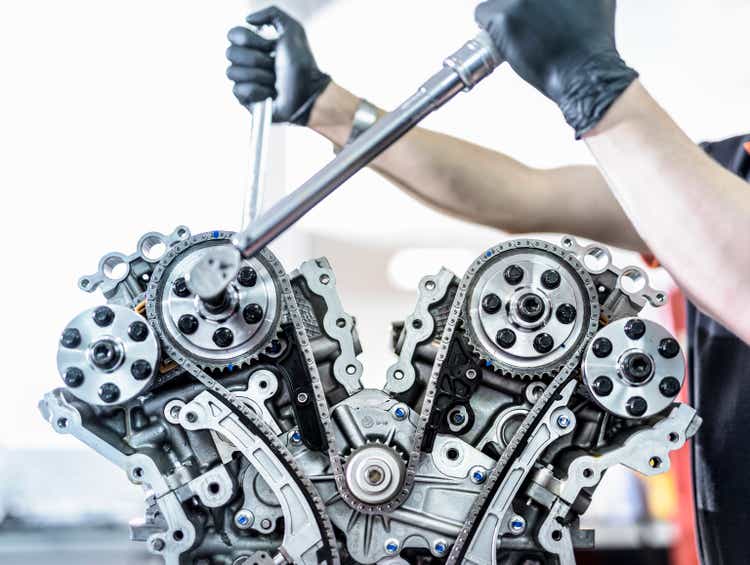 Engineer working on engine in racing car factory, close up