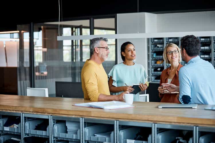 Executives discussing at desk in textile factory