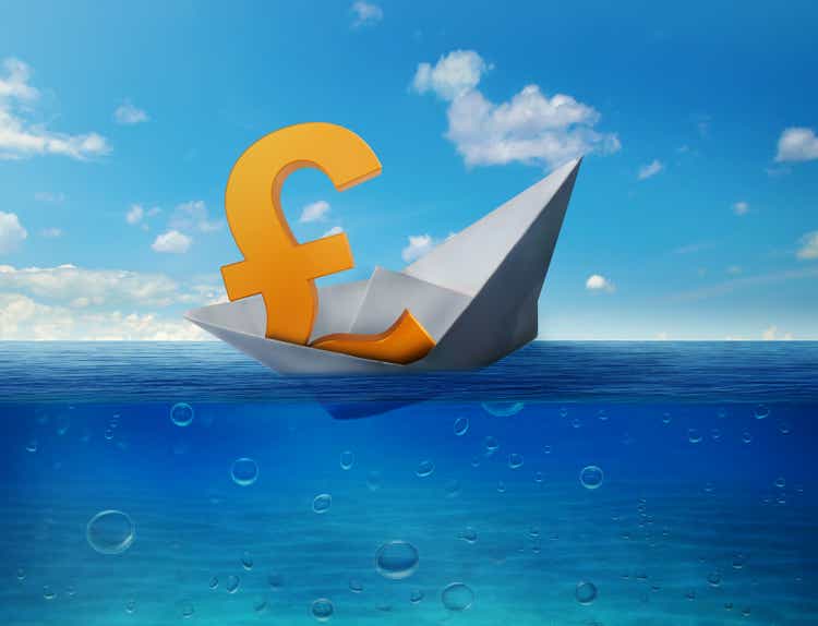 Pound sinking in the sea as symbol of future UK economy depression recession and economic downturns