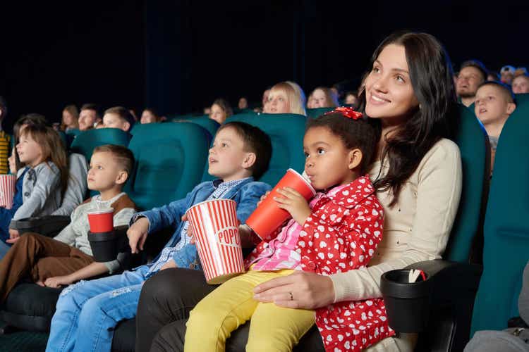 Children with parents enjoying a movie together at the cinema