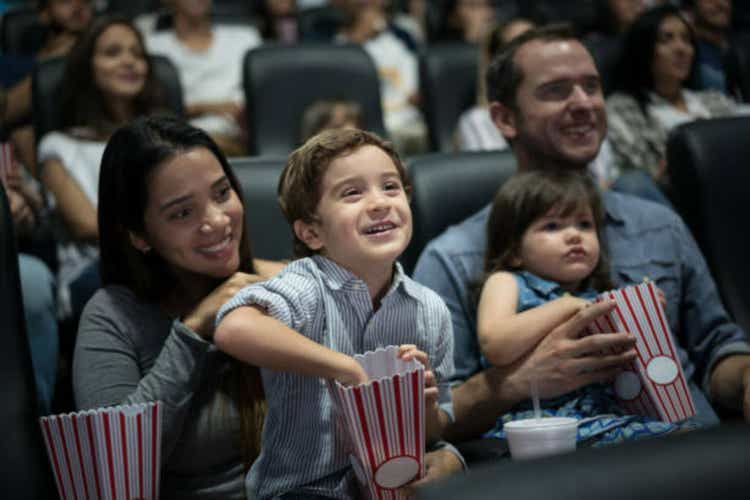 Portrait of a happy family in movies eating popcorn