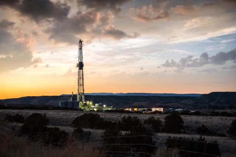 Beautifully Lit Fracking Drill Rig under a Dramatic Sunset Sky