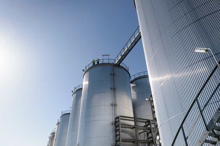 Worker on top of storage tanks in oil blending factory