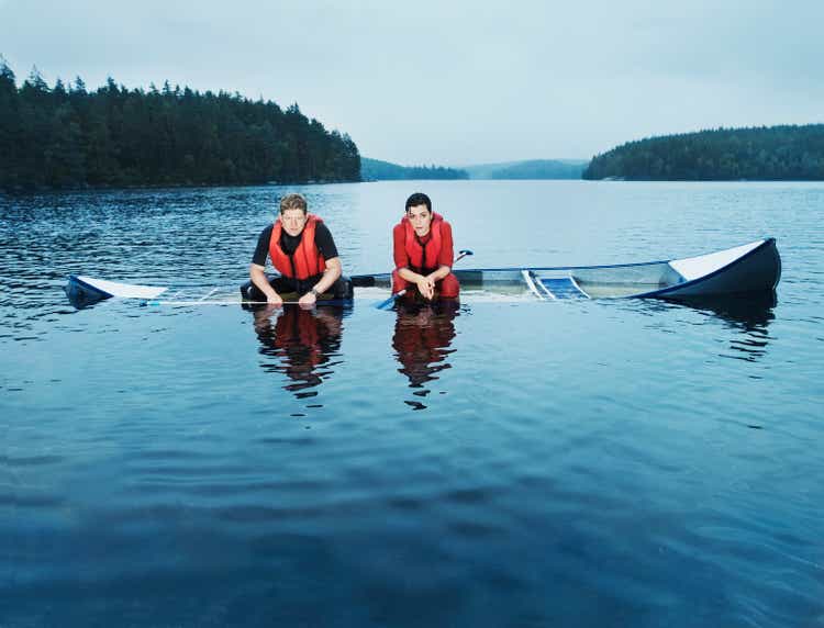 Man and woman sitting in sinking canoe