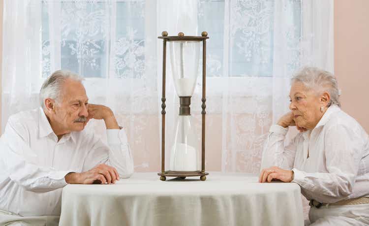 Senior couple staring at hourglass