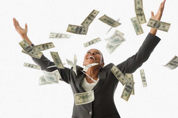 African American businesswoman throwing money in the air