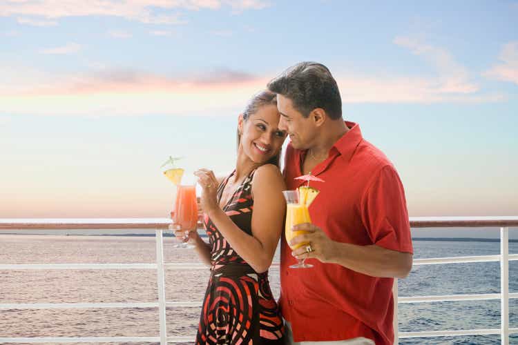 Hispanic couple with cocktails on ship