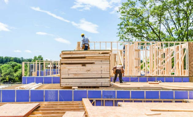 Construction workers building new modern townhouses on Mount Vineyard Property by Pulte Group