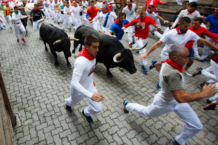 Bulls and people running on the street during the festival of San Fermin