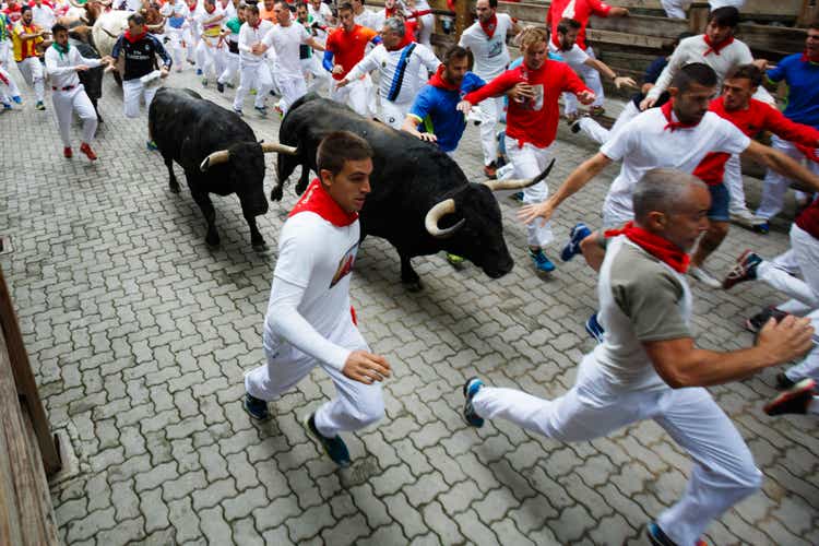 Stieren und Menschen, die auf der Straße während des Festivals von San Fermin