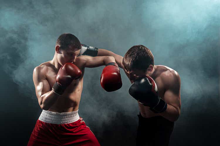 Two professional boxer boxing on black smoky background
