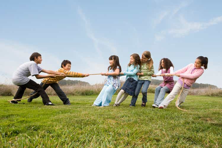 Multi-ethnic children playing tug-of-war