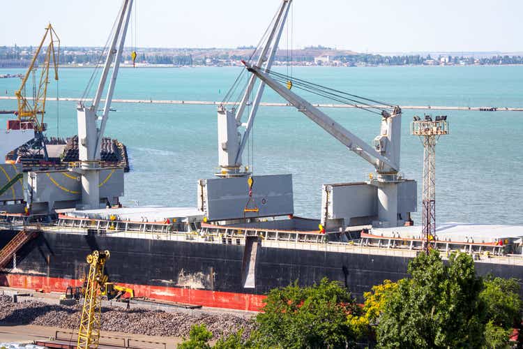 Vessel dry cargo on loading by iron ore, unloading in port. Bulker in port.