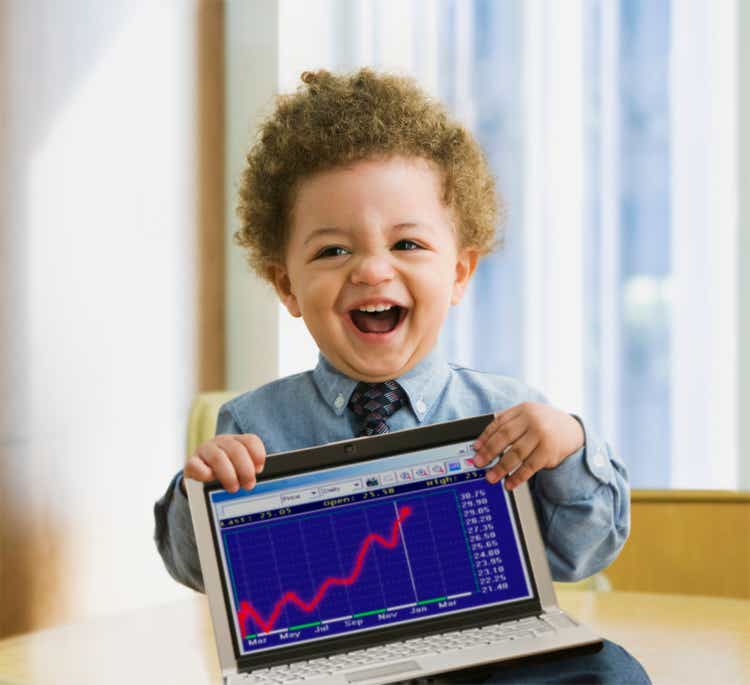 Mixed Race baby holding laptop with graph