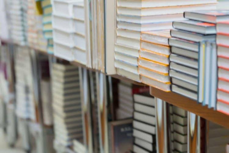 Abstract blurred of stops of books, textbooks or fiction in book store or in library. Education, school, study, reading fiction concept. For abstract background