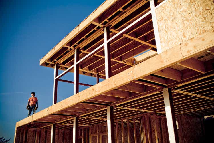 Man standing on house under construction