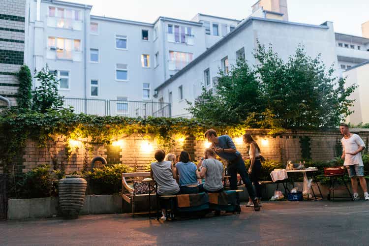 Group Of Friends Enjoying Evening Barbecue Meal Together