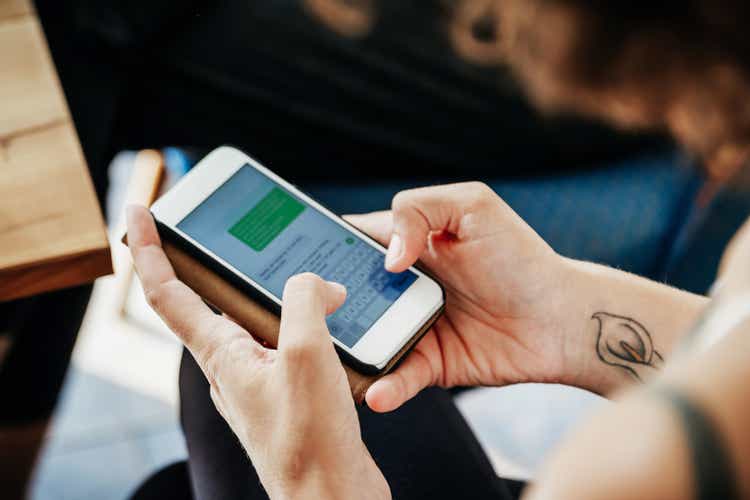 Close Up Of Woman Messaging Friends Using Smartphone