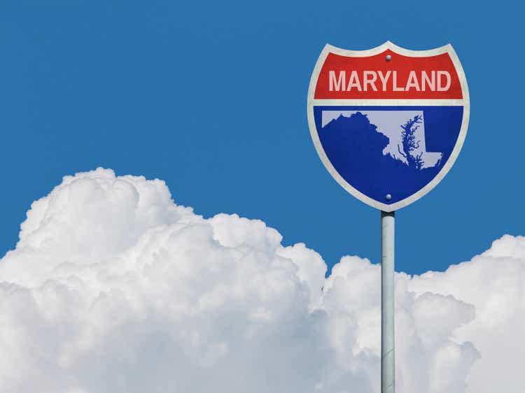 Highway sign for Interstate road in Maryland with map in front of clouds