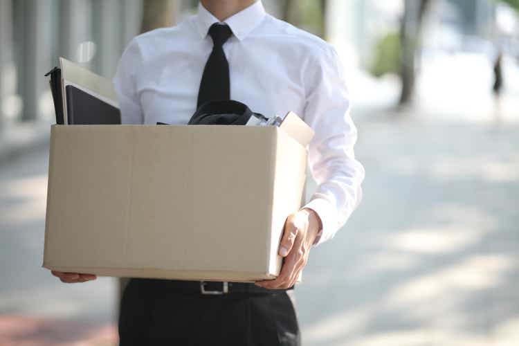 Close-up Of Unemployed Businessperson Carrying Cardboard Box