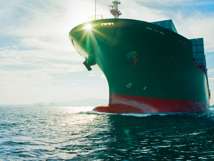 Sun shining through bow of cargo ship