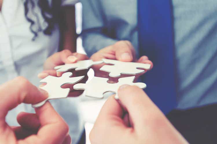 Group of business people holding a jigsaw puzzle pieces.