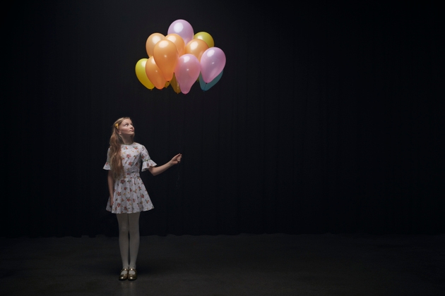 Girl holding balloons and looking at them