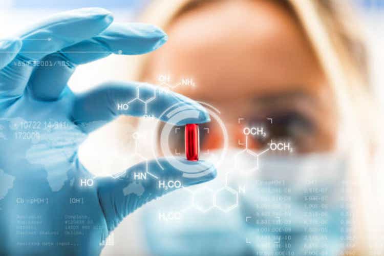 An attractive young woman, a red, transparent pill