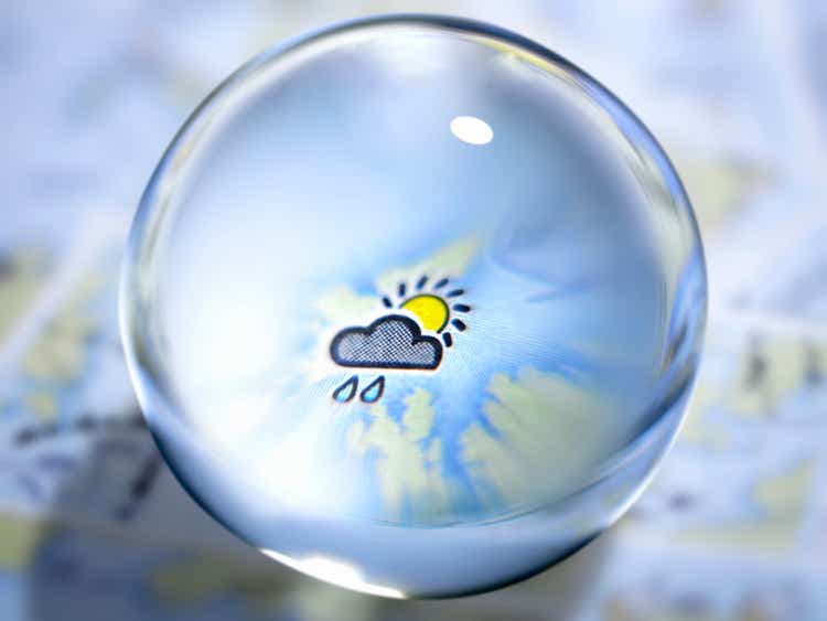 Close up of glass ball with rain cloud and sun in center