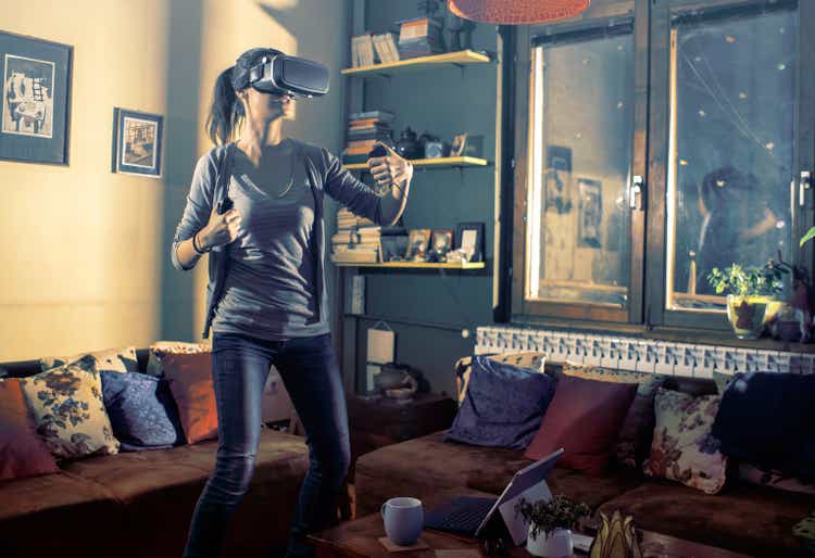 Gamer playing with virtual reality headset at smart home