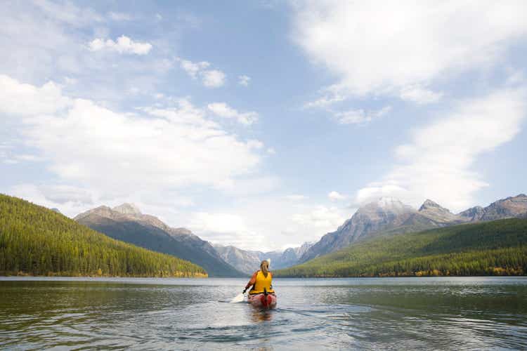 A young woman kayaking on a lake.