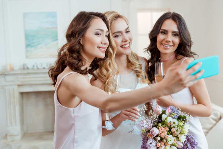 bride with bridesmaids taking selfie