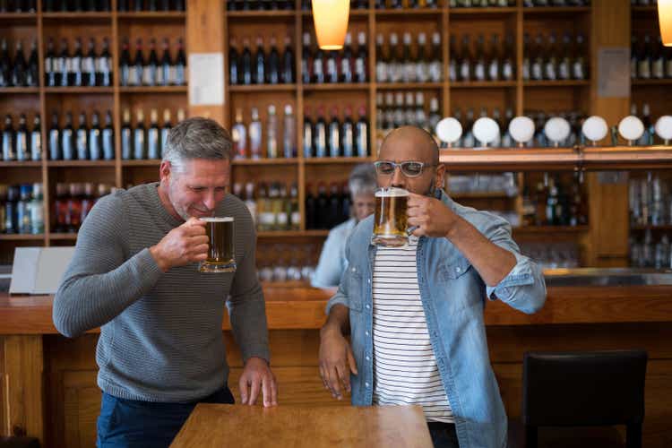 Twee mannen die beer op glas in restaurant