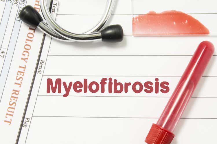 Diagnosis of Myelofibrosis. Laboratory blood bottle (tube), glass slide with blood smear, hematology test, stethoscope lying on notebook with printed text hematological diagnosis of Myelofibrosis