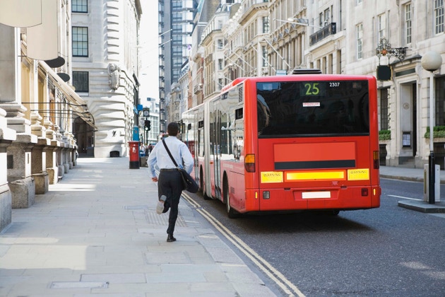 Businessman running after bus in London, England